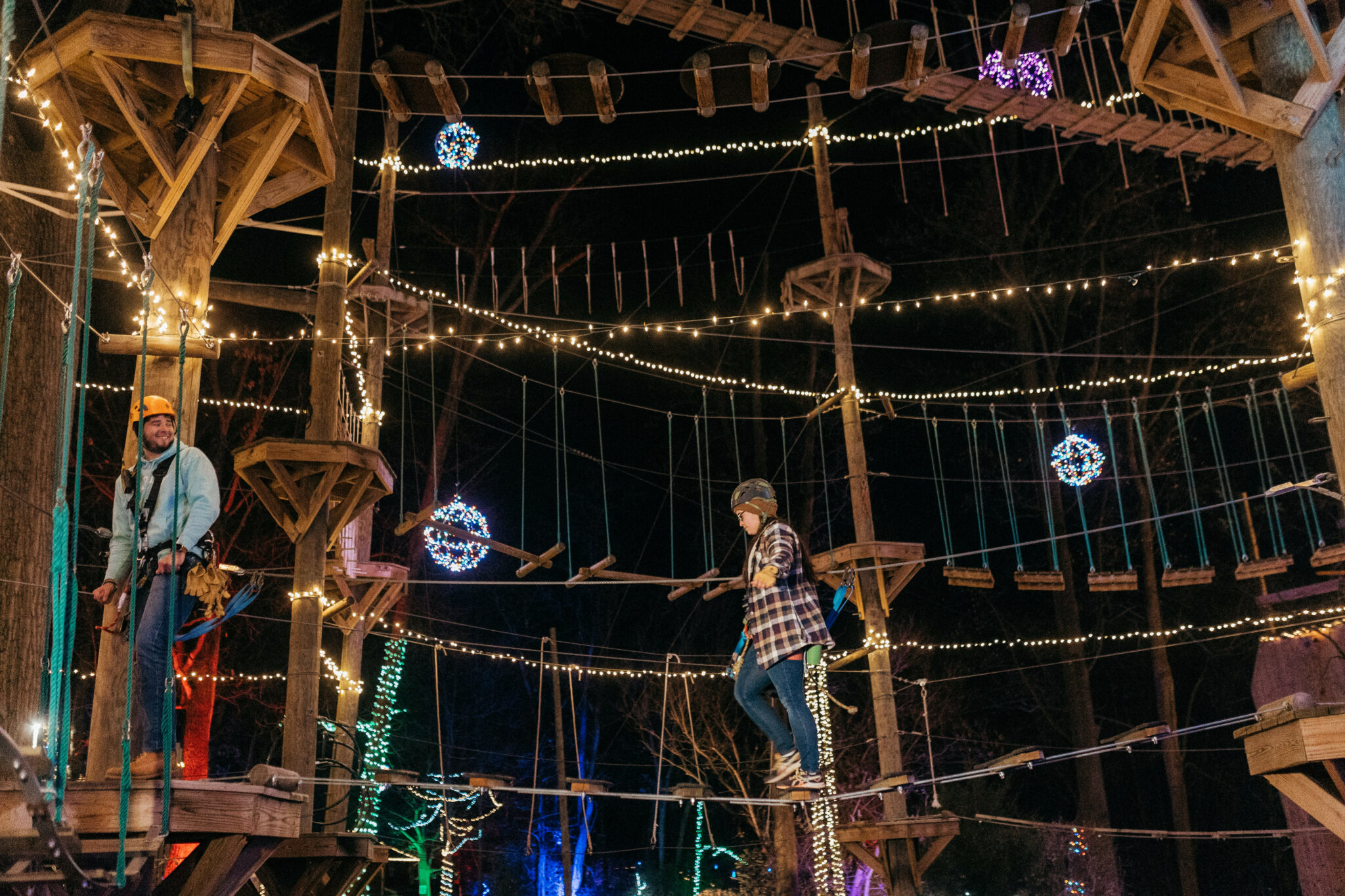 People Walking On The Festively Illuminated Ropes Course At Refreshing Mountain Retreat And Adventure Center